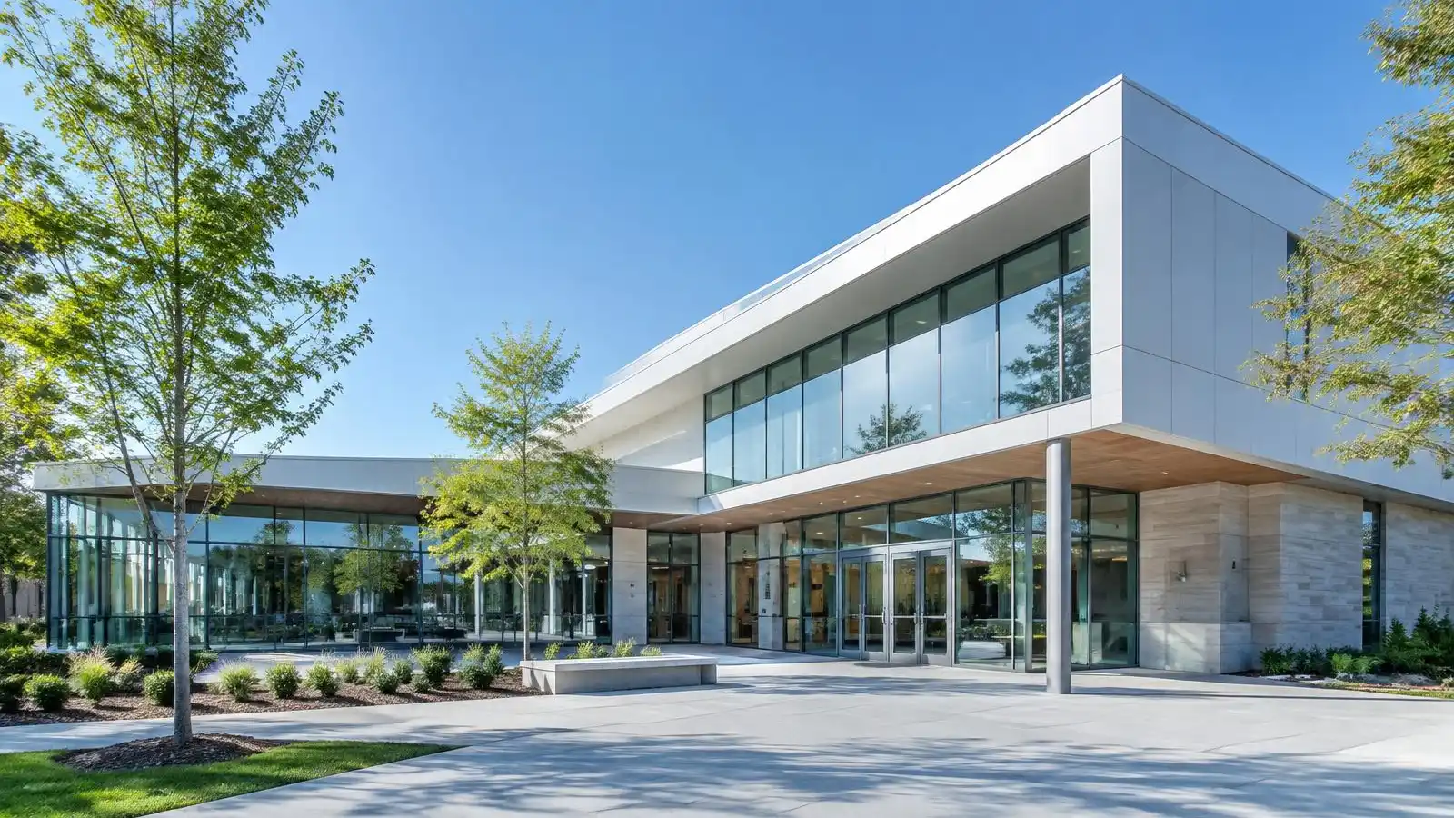 Sunlit modern community building with trees and blue sky